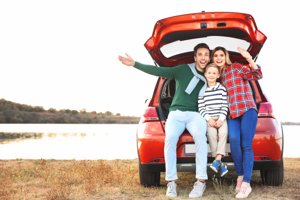 Familia viajando junta en carro por el crédito de vehículos nuevos