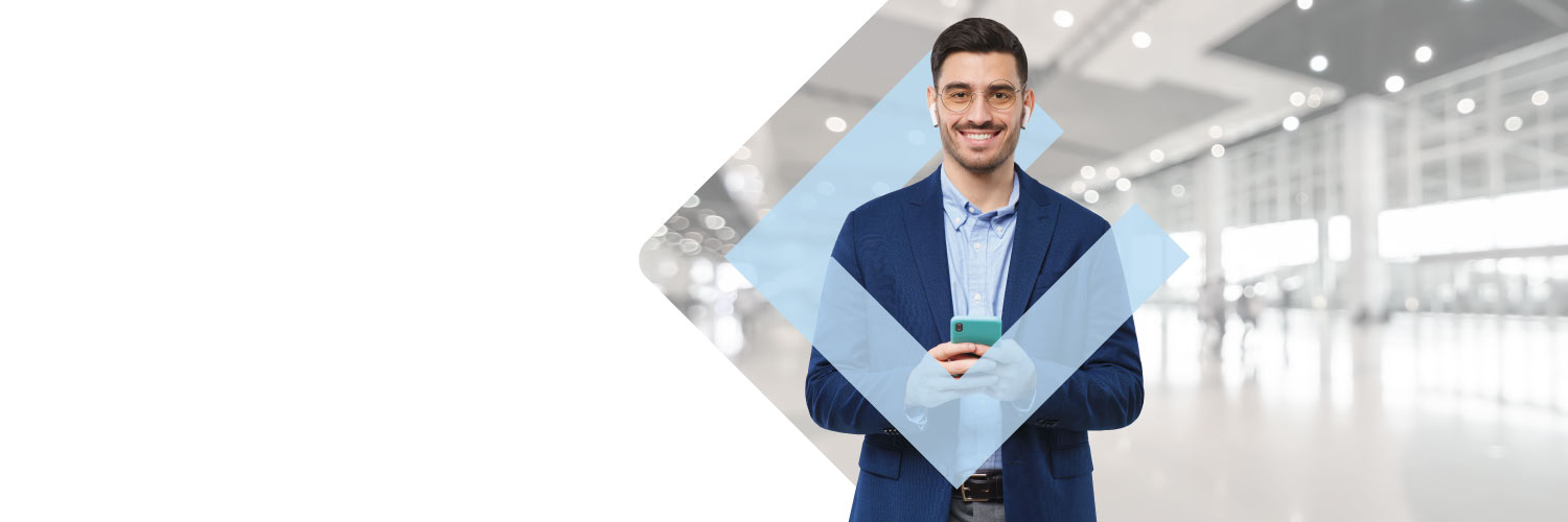 Ejecutivo joven mirando su celular mientras se prepara para viajar con su crédito rotativo.