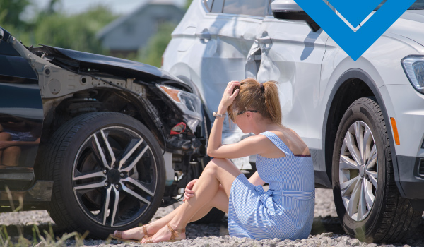 Mujer sentada visualizando daños de accidente