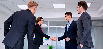 Cuatro empresarios dándose la mano luego de un leasing operativo